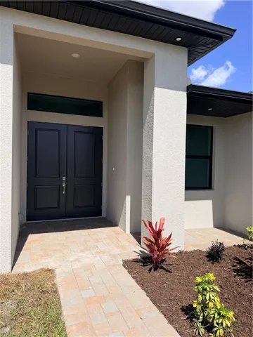 Entrance to property featuring stucco siding and a porch