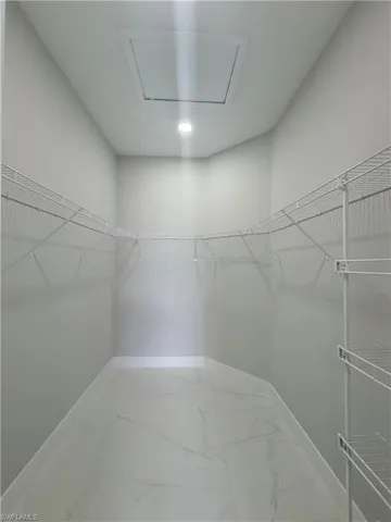 Walk in closet with light marble finish floors