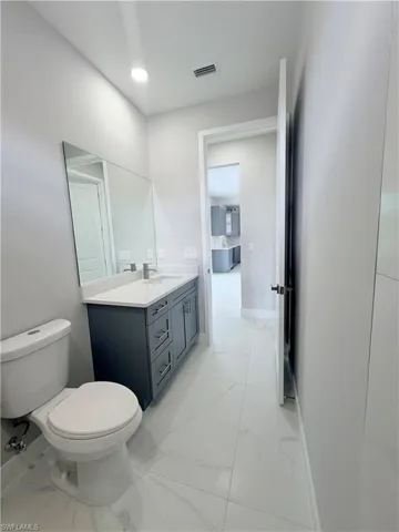 Bathroom with vanity and light marble finish flooring