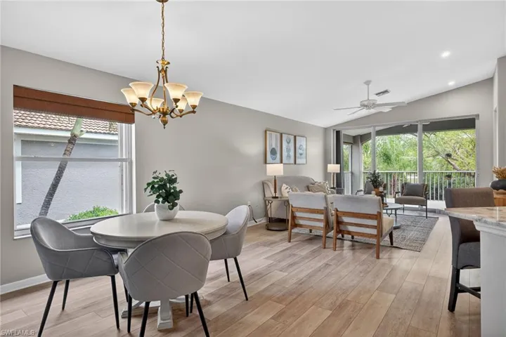 Dining area featuring light wood-type flooring, a ceiling fan, lofted ceiling, and healthy amount of natural light