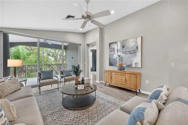 Living area with ceiling fan, wood finished floors, recessed lighting, and vaulted ceiling