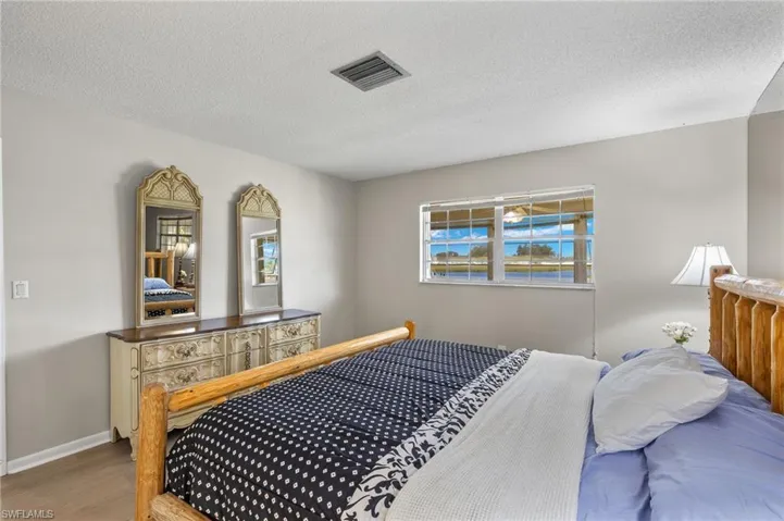 Bedroom featuring hardwood / wood-style flooring and a textured ceiling
