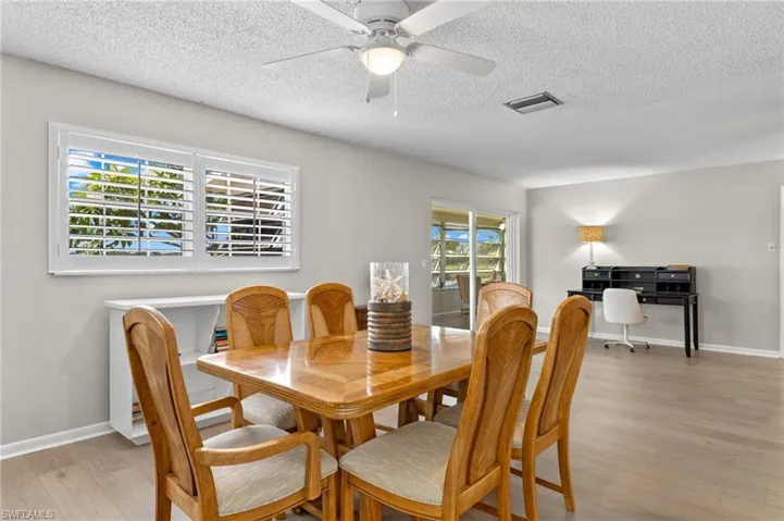 Dining space featuring a textured ceiling, plenty of natural light, ceiling fan, and light wood-type flooring
