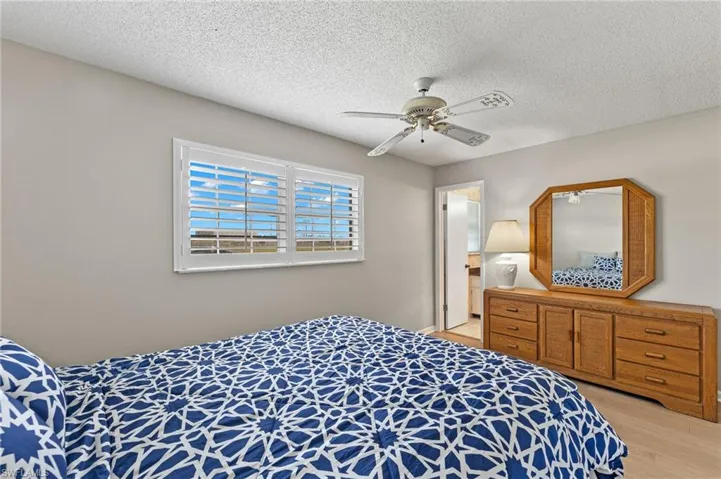 Bedroom featuring light wood-type flooring, ceiling fan, and a textured ceiling
