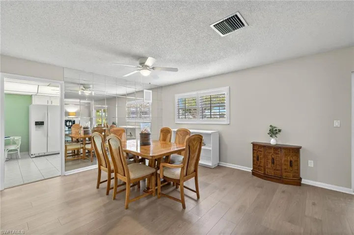 Dining space featuring ceiling fan, light hardwood / wood-style floors, and a textured ceiling