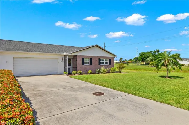 Ranch-style home featuring a front lawn and a garage