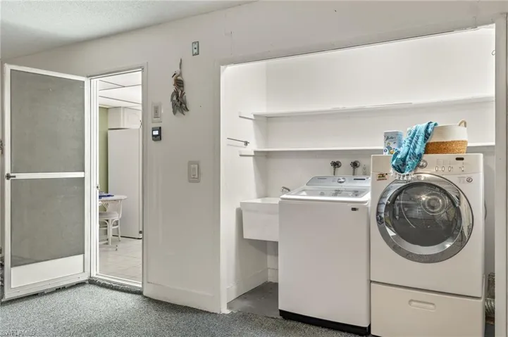 Laundry room with separate washer and dryer, a textured ceiling, tile floors, and hookup for a washing machine