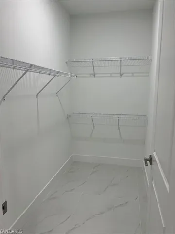 Bathroom with double vanity, an enclosed shower, and tile floors