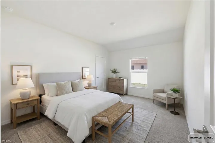 Bedroom with light carpet and lofted ceiling