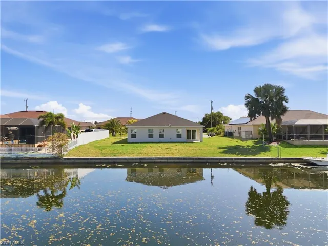 Rear view of property with a sunroom, a water view, and a residential view