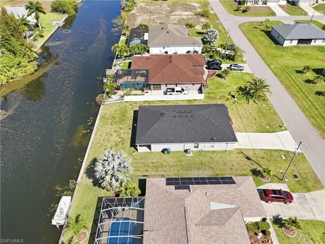 Aerial view of residential area featuring a nearby body of water