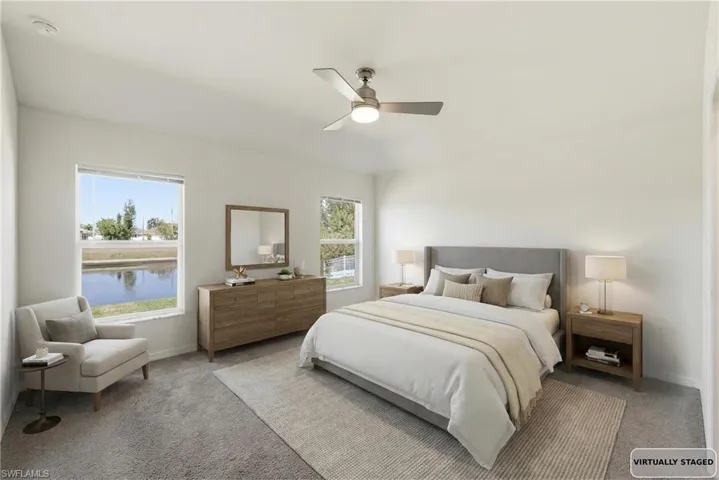 Carpeted bedroom with a ceiling fan, a water view, and lofted ceiling