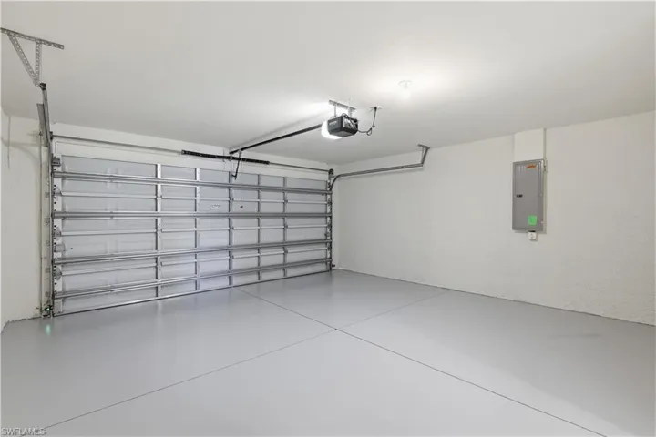 Garage featuring electric panel and a garage door opener