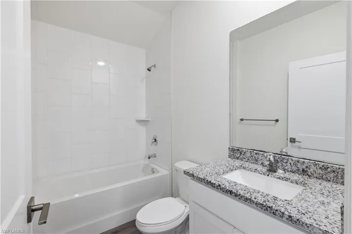 Bathroom featuring vanity and washtub / shower combination
