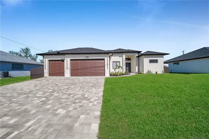 Prairie-style home with a garage, a front lawn, and central air condition unit
