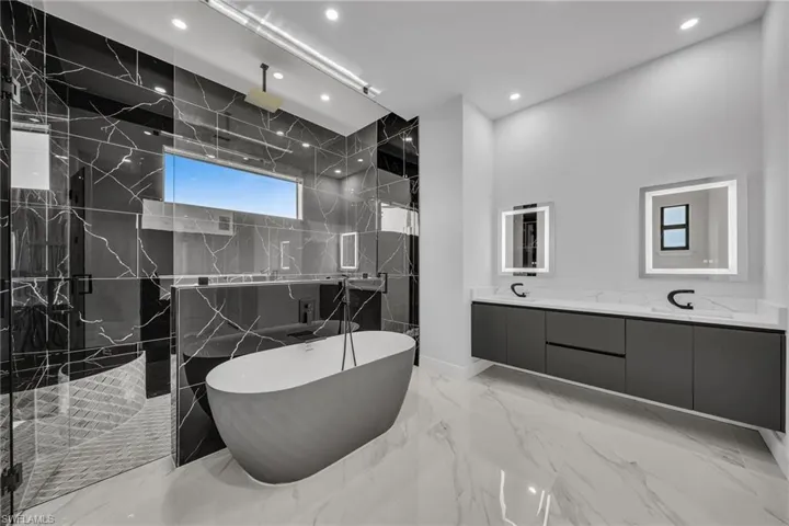 Bathroom featuring vanity and independent shower and bath