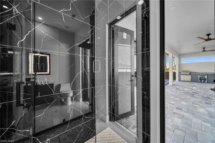 Bathroom featuring a tile shower and ceiling fan