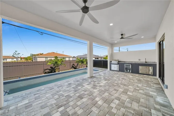 View of swimming pool with a patio, ceiling fan, and exterior kitchen