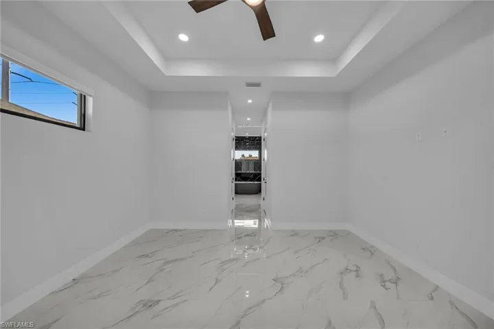 Empty room with a raised ceiling and ceiling fan