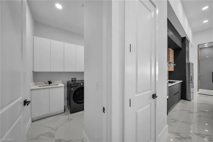 Laundry area with cabinets, sink, and washer / clothes dryer