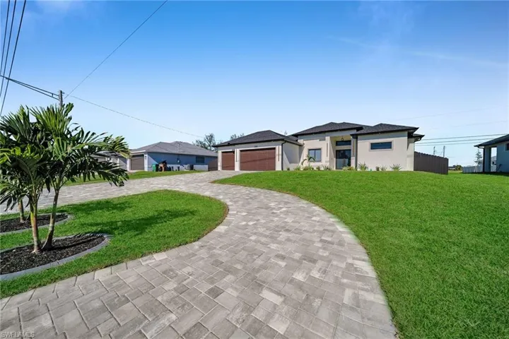 View of front of house featuring a front yard and a garage