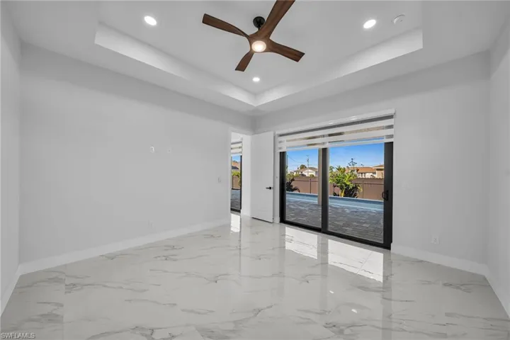 Spare room with a tray ceiling and ceiling fan