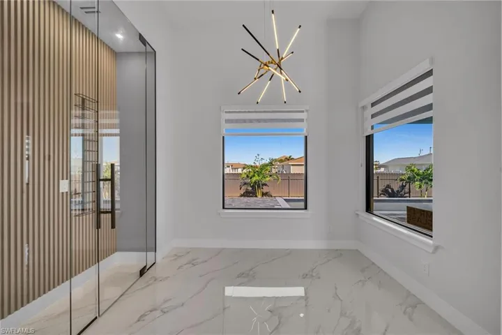Empty room featuring a notable chandelier and a wealth of natural light