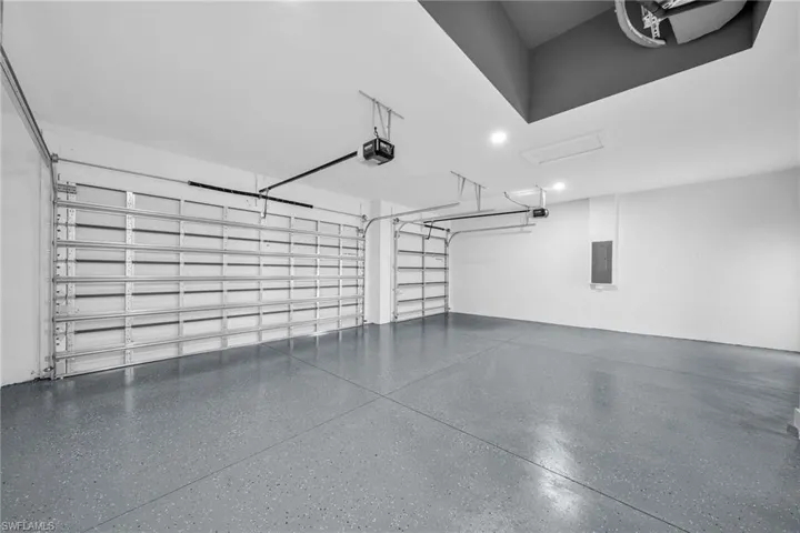 Garage featuring electric panel and a garage door opener