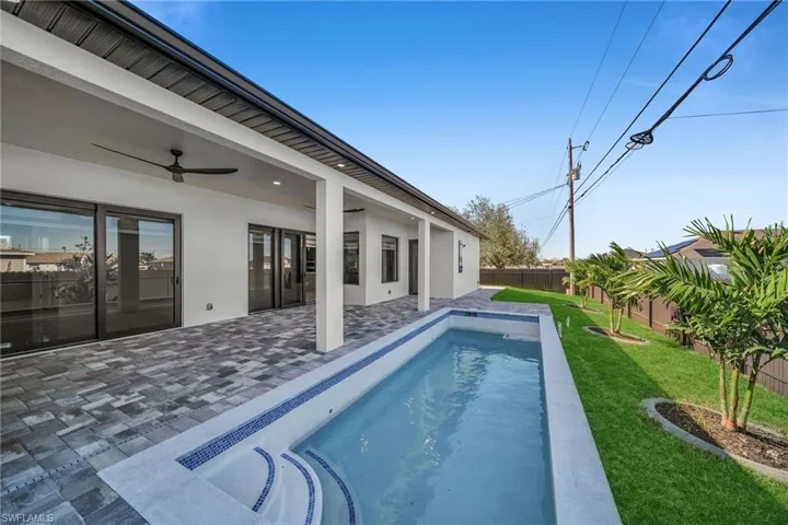 View of pool featuring ceiling fan, a yard, and a patio