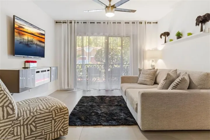 Living room featuring tile floors and ceiling fan