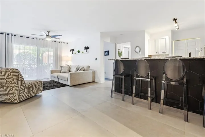 Living room featuring ceiling fan and light tile floors