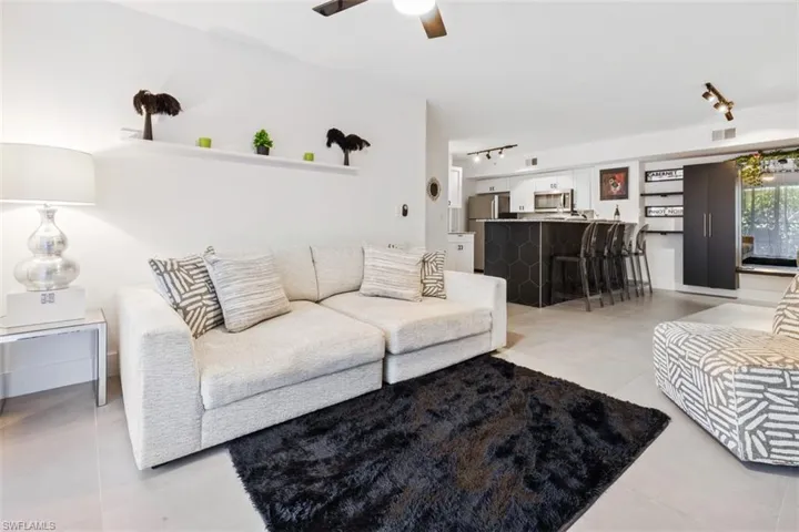 Tiled living room with ceiling fan and rail lighting