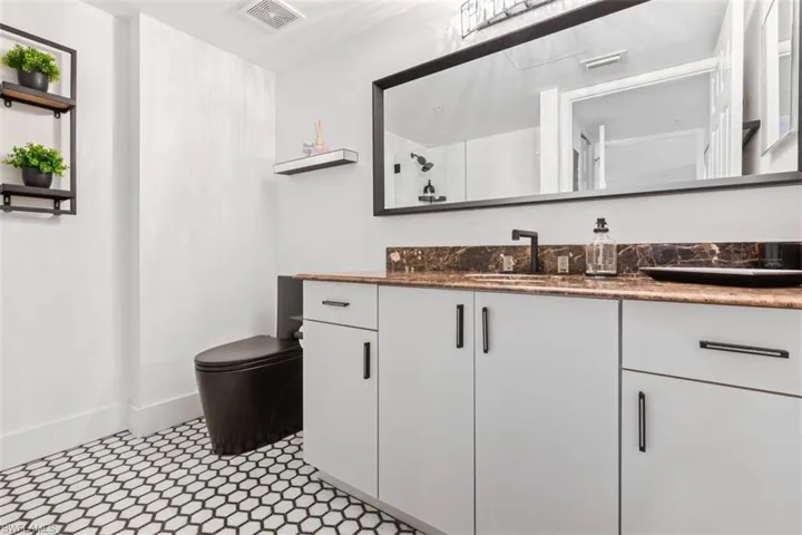 Bathroom featuring tile floors, vanity, and toilet
