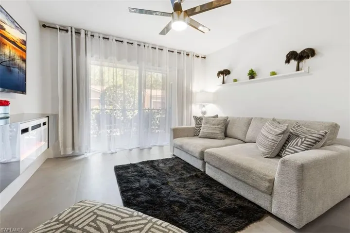 Living room with ceiling fan and tile floors