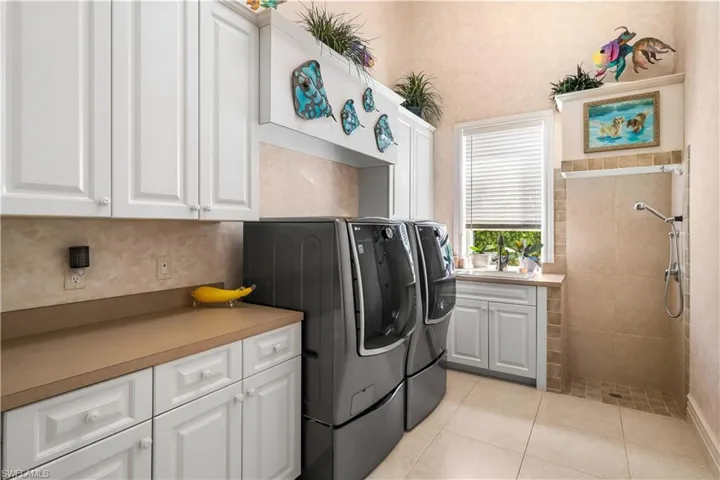 Large Laundry room with a dog washing shower! Lots of storage and natural light. This is the downstairs laundry room.  The 2nd laundry is located on the second level.