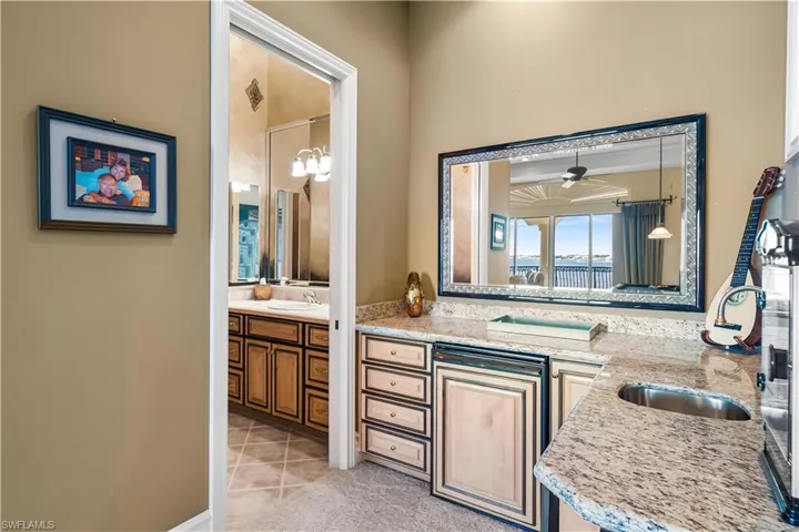 Lovely butler style area in the game/theater room on the second level.  It offers a refrigerator, icemaker and sink. Full bath is through the door on the left with a walk in shower.