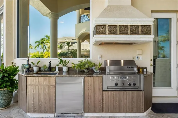 Outdoor kitchen offers a gas grill, refrigerator, sink. Entertainers dream area!!!