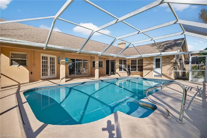 Outdoor pool featuring a sunroom, a lanai, french doors, and a patio