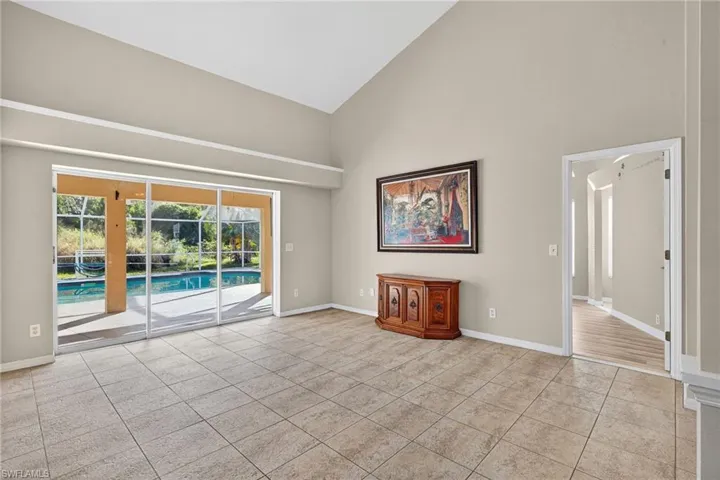 Unfurnished room featuring high vaulted ceiling and light tile patterned flooring