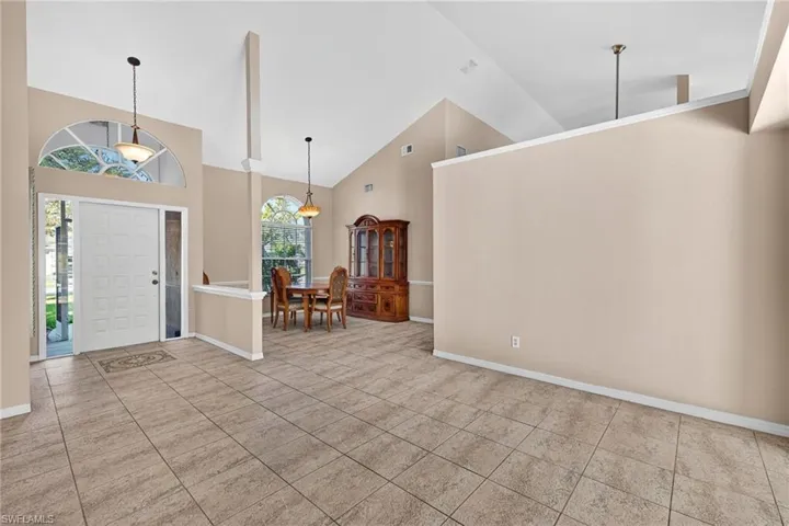 Entryway featuring high vaulted ceiling and light tile patterned flooring