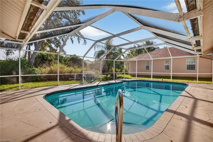 Swimming pool with a lanai, a sunroom, and a patio area