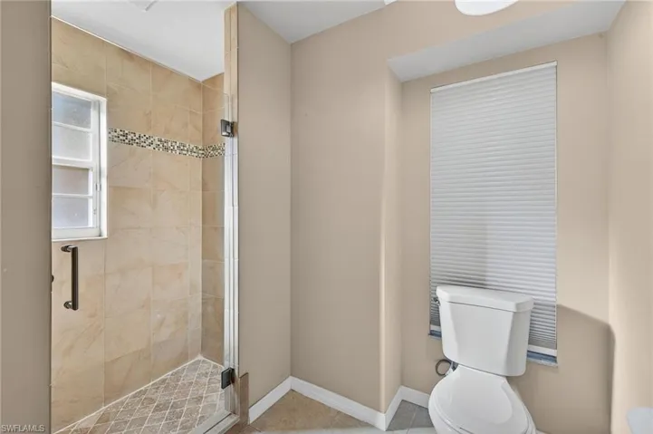 Bathroom with a stall shower and tile patterned floors
