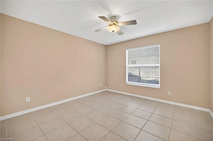 Spare room with light tile patterned flooring and a ceiling fan
