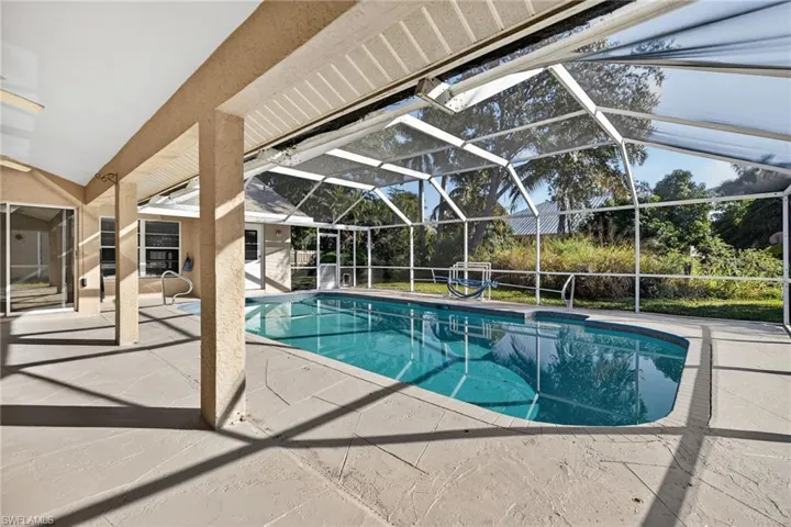 Outdoor pool with a patio, glass enclosure, and a sunroom