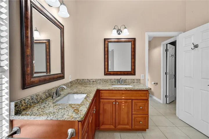 Bathroom with double vanity and light tile patterned floors