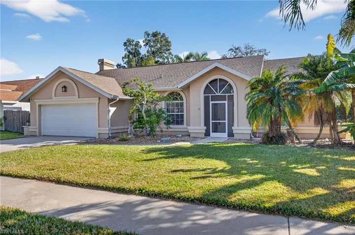 Single story home with stucco siding, a front yard, a chimney, and concrete driveway