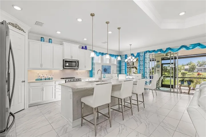 Expansive kitchen featuring stainless appliances and decorative backsplash