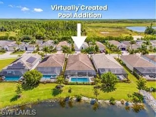 Aerial view showcasing a residence with an in-ground swimming pool, expansive manicured lawn, mature landscaping with palm and shade trees, waterfront access along the property's rear boundary, and a tile roof with neutral exterior finishes