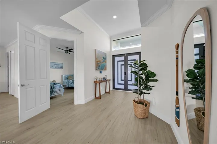 Foyer featuring crown molding, light wood-style floors, baseboards, a ceiling fan, and recessed lighting
