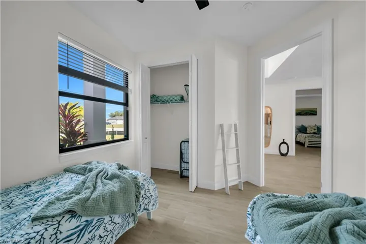Bedroom with light wood-style flooring, baseboards, and a ceiling fan